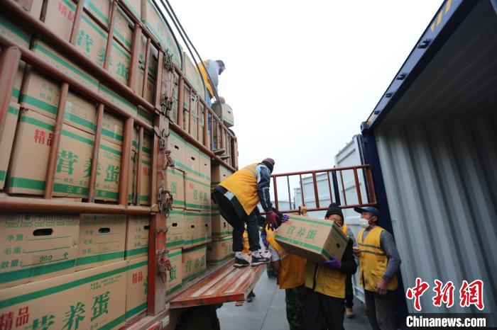 圖為鐵路裝卸作業(yè)人員正在將云南特色農(nóng)產(chǎn)品裝入集裝箱?！詈?攝