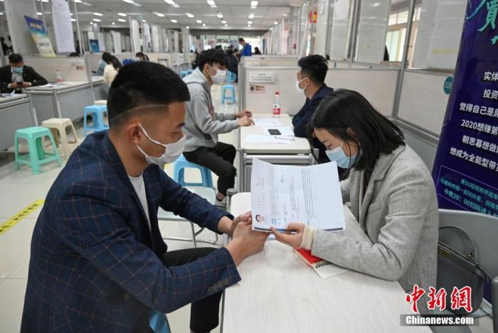 4月14日，招聘者在查看求職者簡歷。<a target='_blank'  data-cke-saved- >中新社</a>記者 王剛 攝