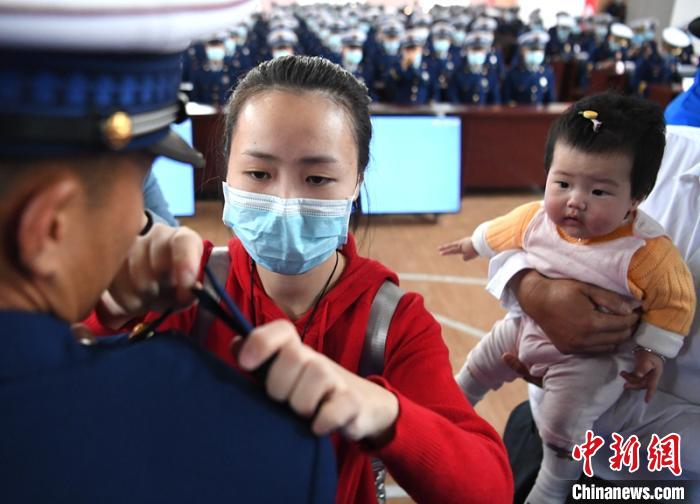 新消防員楊振的妻子彭莉與女兒現(xiàn)場(chǎng)見(jiàn)證丈夫加入“火焰藍(lán)”的神圣時(shí)刻?！⒅铱?攝