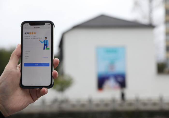 在浙江省杭州市臨安區(qū)天目山鎮(zhèn)，一名居民在“杭州健康碼”海報上掃碼申領個人二維碼。新華社發(fā)