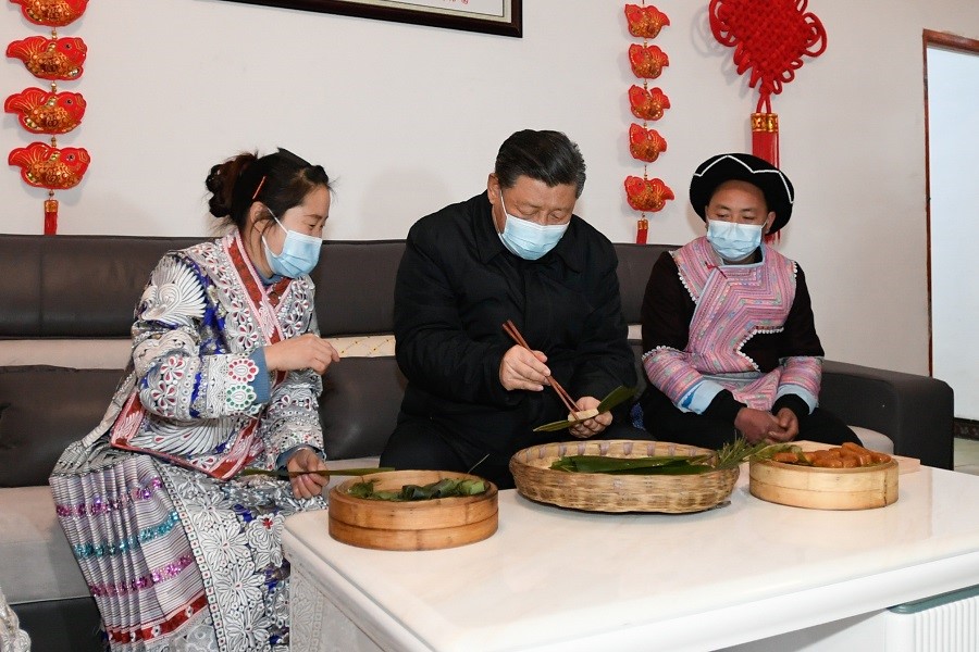 2021年2月3日下午，習(xí)近平在貴州畢節(jié)市黔西縣新仁苗族鄉(xiāng)化屋村苗族村民趙玉學(xué)家，同一家人邊聊家常邊制作當(dāng)?shù)貍鹘y(tǒng)節(jié)日食品黃粑。新華社記者 李學(xué)仁 攝